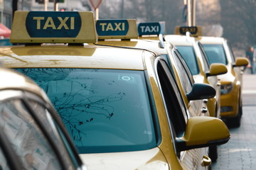 Taxi. Lange gelbe Taxischlange aus Taxis steht auf Strasse am Bahnhof