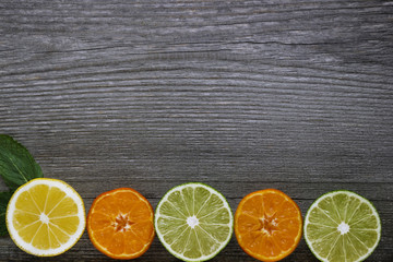 Fototapeta na wymiar Lemons, tangerines and limes on grey wooden table.