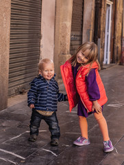 Brother and sister are walking by the street in Tarragona, Spain