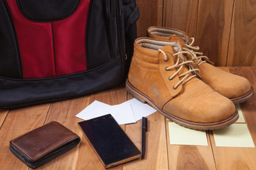 Outfits and accessories of traveler on wooden background