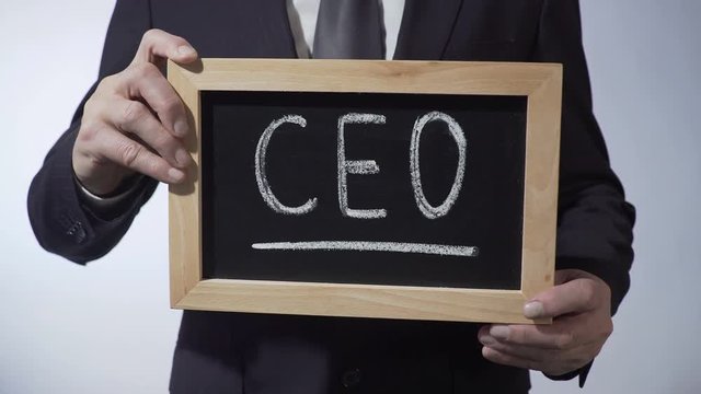 CEO written on blackboard, man in classic suit holding sign, business strategy