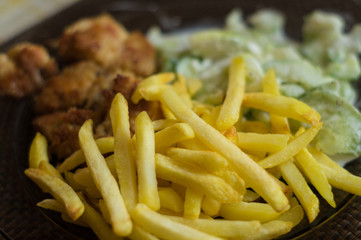 dinner with chips, frien meat and cucumber salad