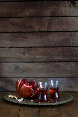 Fresh pomegranates and juice on copper plate. On wooden background. Free space for text. Place for wording
