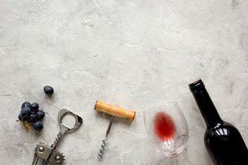 bottle of red wine and corkscrew on stone background top view mockup