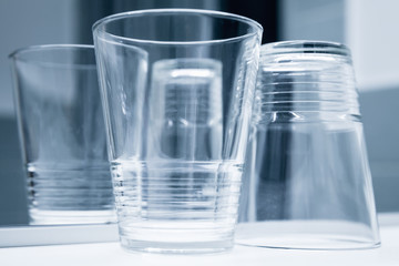 Empty glasses stand on white shelf