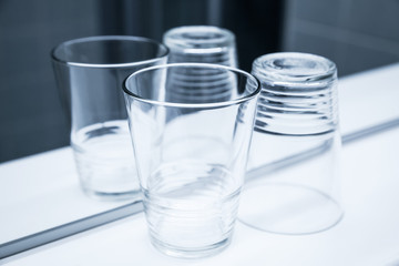 Two empty glasses stand on white shelf