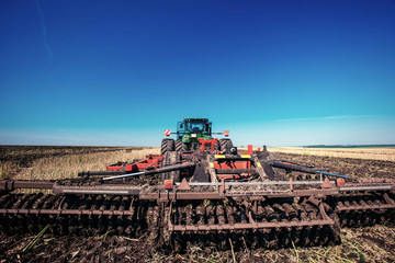 Tractor plowing farm field in preparation for spring planting