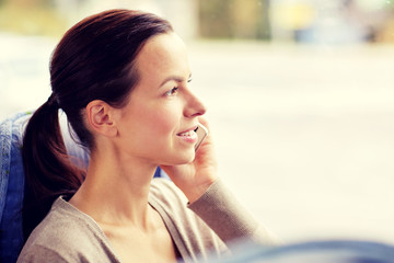 happy woman in travel bus calling on smartphone