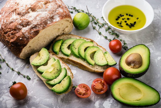 ciabatta with sliced avocado, tomatoes and herbs,  healthy food background