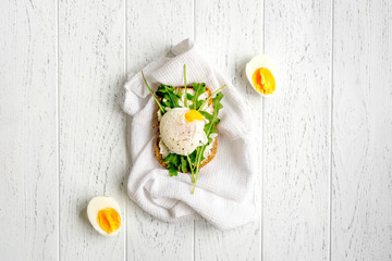 sandwich with poached eggs on wooden background top view mockup