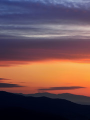 Sunrise in Slovakia. Orange sun sky over dark mountains. Romantic atmosphere. Fog hills at sunset.