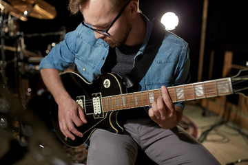 Obraz premium man playing guitar at studio rehearsal