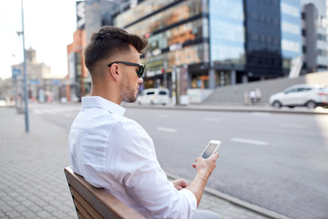 close up of man texting on smartphone in city