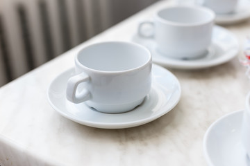 Close up coffee cup on wood table at sunset or sunrise beach.