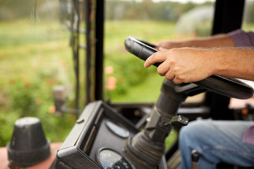 senior man driving tractor at farm © Syda Productions