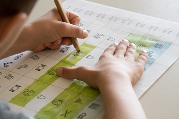 Ein Schüler malt einen Stundenplan mit Symbolen an