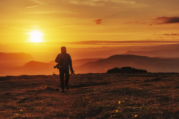 Fototapeta na wymiar Happy man standing on a cliff at sunset