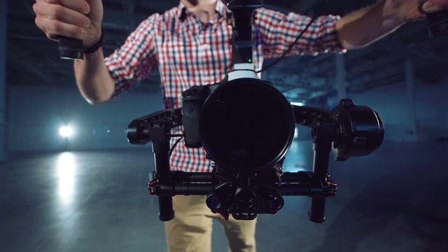 The operator with the camera mounted on the three-axis handheld gimbal electronic stabilizator runs up directly to the camera