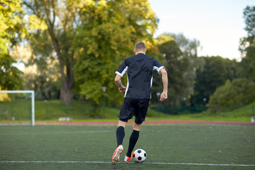 soccer player playing with ball on football field