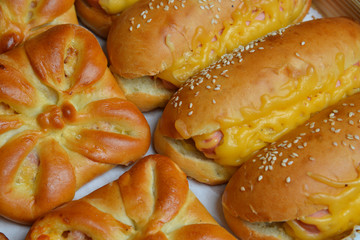 Homemade sesame buns with cheese on tray, closeup