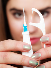 Woman holding small toothbrush and dental floss