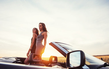 Young two women at a photo shoot. Girls gladly posing