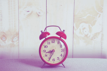 Red clock on wood background.