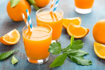 Abwaschbare Fototapete Saft Orangensaft im Glas und frische Früchte mit Blättern auf Holzhintergrund, Vitamingetränk oder Cocktail