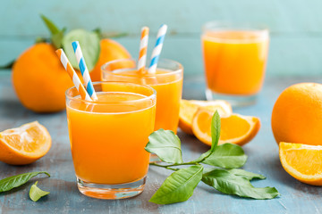 Jus d& 39 orange en verre et fruits frais avec des feuilles sur fond de bois, boisson vitaminée ou cocktail