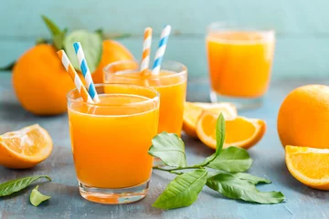 Photo sur Plexiglas Jus Jus d& 39 orange en verre et fruits frais avec des feuilles sur fond de bois, boisson vitaminée ou cocktail