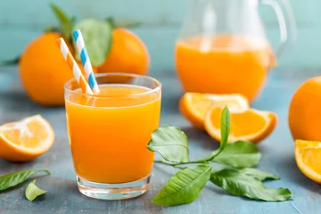 Foto auf Acrylglas Saft Orangensaft im Glas und frische Früchte mit Blättern auf Holzhintergrund, Vitamingetränk oder Cocktail