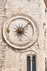 Fototapeta na wymiar Clock tower of old stone church inside Diocletian City in Split, Croatia 