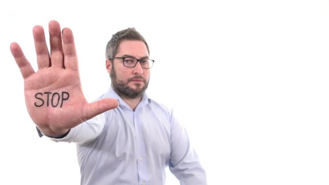 Handsome man rising hand showing word STOP on palm disapproval expression indoor white background medium close up, soft focused businessman