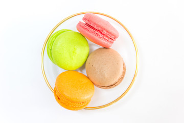 Sweet and colourful french macaroons or macaron in a glass bowl on white background, Top view with copy space for your text.
