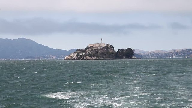 Panoramic boat sea view of Alcatraz island, warden's house and lighthouse of the prison. Bay of San Francisco, United States. Traveling in California. Popular tourist attraction in San Francisco.