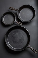 Cast iron skillet collection on black background