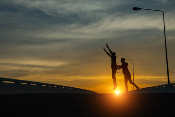 silhouette couples Jumping at sunset