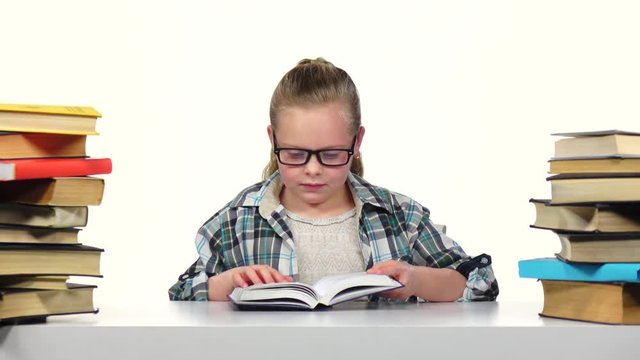 Girl chooses a book and starts to read it. White background