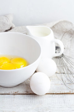 ingredients for omelet on a white wooden background