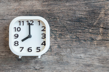 Closeup white clock for decorate in 8 o'clock on old wood floor textured background with copy space