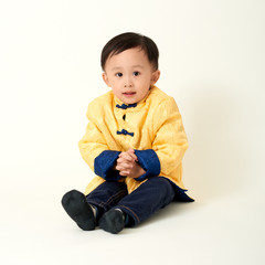 Chinese baby boy in traditional Chinese New Year outfit celebrating Lunar New Year