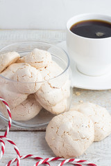 meringue and coffee in a white cup on a white table closeup.