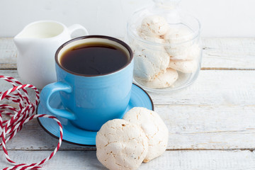 cup of coffee, milk and meringue on wooden background
