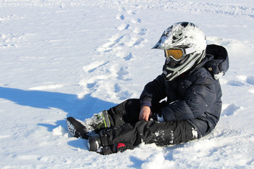 Fototapeta na wymiar Child Wearing a Biking Helmet Sitting in the Snow