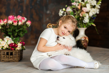 Little girl with a samoyed puppy