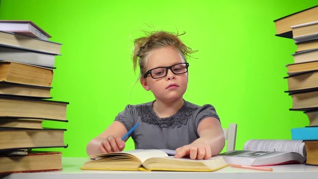 Girl sitting and leafing through the book. Green screen. Slow motion