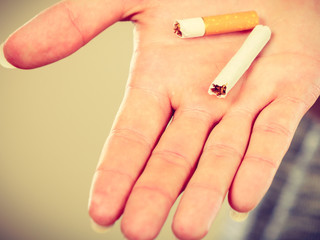 Closeup of broken cigarette on male hand.