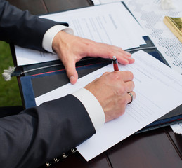 Brautpaar unterschreibt den Ehevertrag nach der Trauung