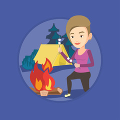 Woman roasting marshmallow over campfire.