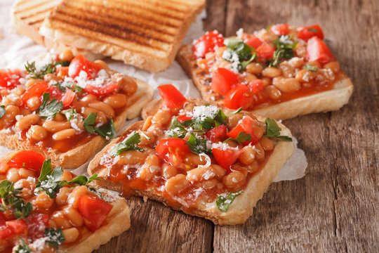 Tasty sandwich with white beans, tomatoes, cheese and herbs closeup. horizontal